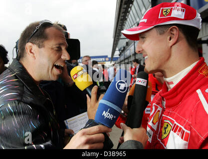 (Dpa) - deutsche Formel1 Rennfahrer Michael Schumacher Ferrari (R) im Gespräch mit der Presse nach dem zweiten Training in Silverstone in England, 8. Juli 2005. Den britischen Grand Prix wird es am Sonntag, 10. Juli 2005 stattfinden. Schumacher fuhr die 10. schnellste Zeit auf die zweite pract Stockfoto