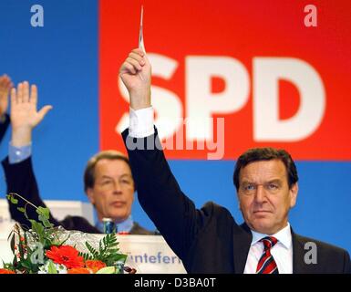 (Dpa) - Bundeskanzler Gerhard Schroeder (vorne) und SPD-Fraktionsführer Franz Muentefering (hinten) für den Koalitionsvertrag beim Parteitag in Berlin, 20. Oktober 2002 stimmen. Der Koalitionsvertrag mit der grünen Partei für die kommende Amtsperiode der Regierung wurde mit großer Mehrheit Witz angenommen. Stockfoto