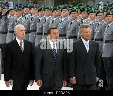 (Dpa) - L-r: bezeichneten deutschen Verteidigung Minister Peter Struck, Bundeskanzler Gerhard Schroeder und polnische Präsident Aleksander Kwasniewski gehen vorbei an einer Front des jungen Rekruten der Bundeswehr in Berlin, 20. Juli 2002. Geschlagen, dient, die Verteidigungsminister am 19. Juli bezeichnet wurde, als Verteidigung Minis Stockfoto