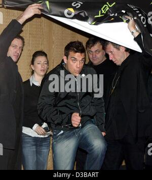 (Dpa) - kommt die britische Pop-Sängerin Robbie Williams (C) auf einer Pressekonferenz sein neue Album "Escapology" in der britischen Botschaft in Berlin, 18. November 2002 zu fördern. Williams kündigte auch die Termine für seine neue Tournee, die in acht Ländern in ganz Europa nächsten Sommer stattfinden wird. Stockfoto