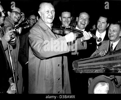 (Dpa-Dateien) - deutsche Bundeskanzler Konrad Adenauer spielt die Geige, die er als Geschenk von Geigenbauern während einer Wahl Kampagne Veranstaltung in Bubenreuth, West Germany, 11. September 1957 vorgestellt wurde. Sie schenkte ihm die Geige mit den Worten "weiterhin die erste Geige spielen". Adenauer posierte mit Stockfoto