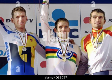 (Dpa) - kolumbianischer Radrennfahrer Santiago Botero (C) Wellen bei der Preisverleihung zusammen mit zweite platzierte deutsche Michael Rich (L) und dritte Spanier Igor Gonzales de Galdeano nach der Männer-Elite trial Rennen der Road Cycling World Championships in Zolder, Belgien, 10. Oktober 2002 Zeit gesetzt. Boter Stockfoto