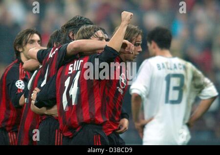 (Dpa) - Bayerns Mittelfeldspieler Michael Ballack (R) ist tief enttäuscht, während der Mailänder Spieler jubilate nach dem Gewinn der UEFA Champions League-Spiel AC Mailand gegen FC Bayern München in Mailand, Italien, 23. Oktober 2002. Milan gewann 2:1. Stockfoto