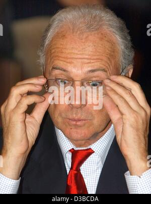 (Dpa) - Franz Beckenbauer, Präsident des deutschen Fußballclub FC Bayern München, stellt seine Brille in einem Hotel in Mailand, Italien, 23. Oktober 2002. Beckenbauer kam nach Mailand zu seinem Verein, während ein UEFA-Champions-League-Spiel gegen den AC Mailand spielen zu sehen. FC Bayern München verloren 2:1. Stockfoto