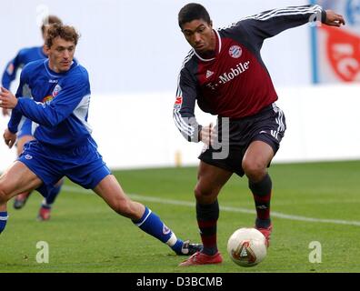 (Dpa) - Bayern brasilianische Stürmer Giovane Elber (R) entkommt Rostocks tschechischen Verteidiger Michal Kovar während der Fußball-Bundesligaspiel FC Bayern Muenchen gegen FC Hansa Rostock in Rostock, Deutschland, 19. Oktober 2002. Tabellenführer FC Bayern München gewinnt 1:0. Stockfoto