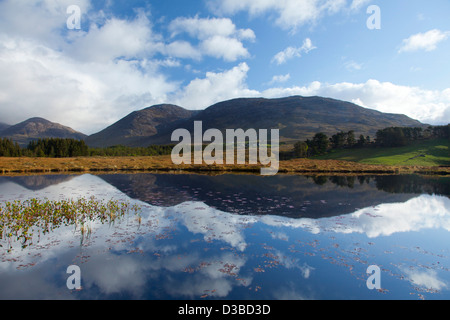 Die Maumturk Mountains spiegelt sich in einem Lough, Connemara, County Galway, Irland. Stockfoto