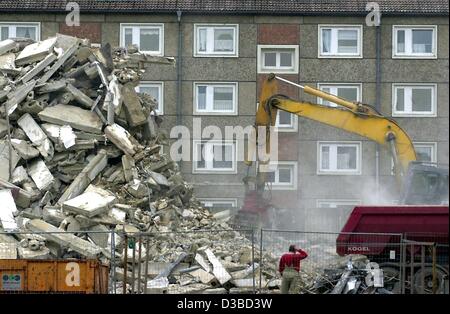 (Dpa) - ein Bagger zerstört die vergoldeten Steinen eine "Plattenbau" Gehäuse Fläche vor die Steinen auf einem LKW in Rathenow, Deutschland, 21. Januar 2003 geladen werden. Viele "Plattenbau" Wohngebiete (industriell vorgefertigtes Template Gebäude) die während der Zeiten der ehemaligen DDR errichtet wurden sind vaca Stockfoto