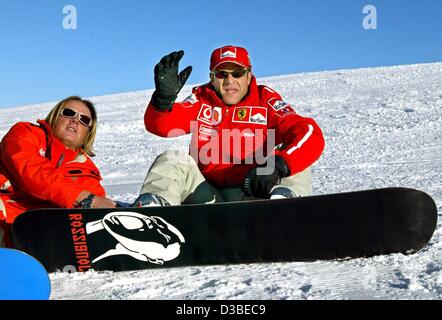 (Dpa) - brasilianischer Formel 1 pilot Rubens Barrichello "Wellenlinien" wie er macht eine Pause von snowboarding in Madonna di Campiglio, Italien, 15. Januar 2003. Auf der linken Seite seines Snowboardlehrer. Das traditionelle Ferrari dreitägige Treffen findet jedes Jahr zu Beginn der Saison in den italienischen Alpen. Stockfoto