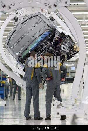 (Dpa) - zwei Arbeiter montieren Teile des neuen VW Touran am Fließband in Wolfsburg, Deutschland, 13. Januar 2003. Der Touran ist ein van, basierend auf dem Modell des VW Golf. Die Beschäftigten waren im Rahmen des Projekts 5000 Mal 5000' (5.000-mal 5.000), die 5.000 neue Arbeitsplätze schaffen soll. T Stockfoto