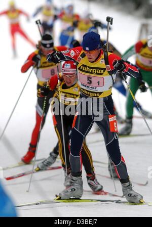 (Dpa) - kämpft französische Biathletin Ferreol Cannard (vorne) bergauf vor deutschen Michael Greis und slowenischen Janez Ozbolt bei den Herren 4 x 7.5 km Staffellauf bei der Biathlon-Weltcup in Oberhof, Ostdeutschland, 11. Januar 2003. Stockfoto