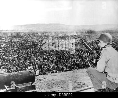 (Dpa-Dateien) - eine bewaffnete US-Soldat wacht über deutsche Kriegsgefangene, die in das Ruhrgebiet von US-Truppen in Deutschland 1945 gefangen genommen wurden. Stockfoto