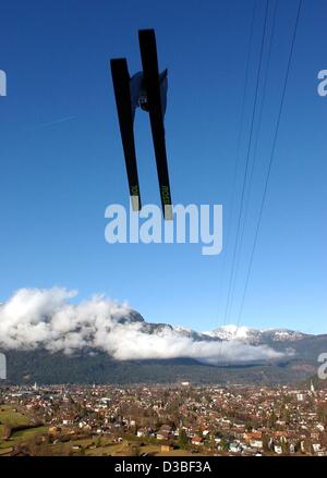 (Dpa) - ist ein Skispringer in der Luft während einer Ausbildung für die vier Hügel-Turnier, mit einem herrlichen Blick über die Stadt Garmisch-Partenkirchen, Deutschland, 1. Januar 2003. Stockfoto