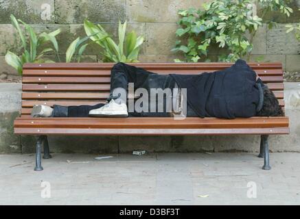 (Dpa) - ein Mann nimmt ein Nickerchen auf einer Bank in einem Park in Palma auf der Resort Insel Mallorca, Spanien, 10. Juni 2003. Mallorca ist die größte Insel der Balearen und gilt als eines der beliebtesten Urlaubsziele in Europa. Stockfoto