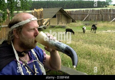 (Dpa) - Roland Bannart, ein Mitarbeiter des Museums, gekleidet in traditioneller Tracht trinkt aus einem Stier Horn bei den Langobarden Workshop in Zehtlingen, Deutschland, 18. Juni 2003. Der germanische Stamm der Langobarden lebten in der Gegend zwischen 180 und 400 n. Chr., ist heute Teil der sächsischen Landeshauptstadt Stockfoto