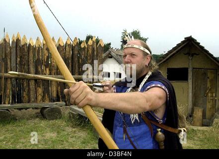 (Dpa) - Roland Bannart, ein Mitarbeiter des Museums, steht in einer Tracht gekleidet und Pfeil und Bogen in seinen Händen hält, um die alten Waffen von den Langobarden in der Langobarden-Werkstatt in Zehtlingen, Deutschland, 18. Juni 2003 demonstrieren. Der germanische Stamm der Langobarden lebten Stockfoto