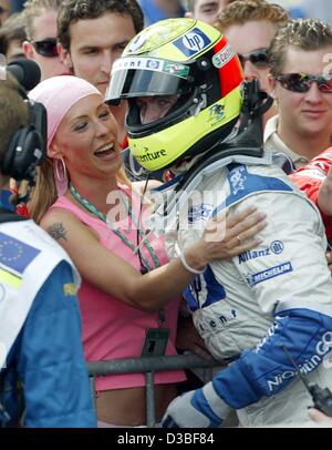 (Dpa) - deutsche Formel 1 pilot Ralf Schumacher (BMW-Williams) glücklich umarmt seine Frau Cora nach dem Gewinn der Europäischen Grand Prix auf dem Nürburgring Rennstrecke, Deutschland, 29. Juni 2003. Mit 43 Punkten in der Gesamtwertung für die WM ist er nun dritte ranking.