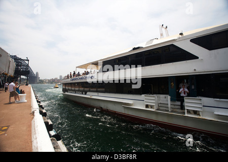Captain Cook Cruise Ferry zieht weg von den Felsen im Hafen von Sydney, Australien Stockfoto