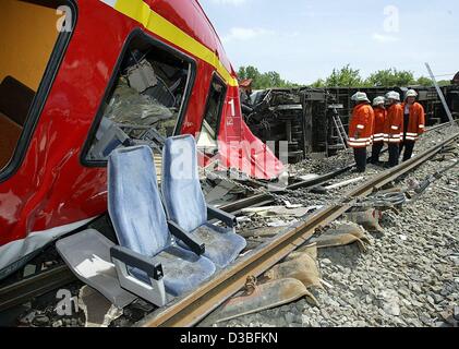 (Dpa) - ein abgestürzter Zug aus den Gleisen ist, zwei Sitze sind auf den Gleisen, Feuerwehrleute beobachten, Schrozberg, Deutschland, 11. Juni 2003. Zwei s-Bahnen kollidierte im ländlichen Südwesten Deutschlands, sechs Menschen getötet und verletzt wurden einige 25. Die Züge prallte frontal auf eine Single-Rail Strecke in der Nähe Stockfoto