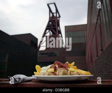 (Dpa) - liegt eine Portion Pommes Frites mit einer Currywurst serviert auf einem Teller auf dem Gelände der stillgelegten Zeche "Zollverein" in Essen, Deutschland, 17. Juni 2003. Deutschen haben ihre "Currywurst" seit mehr als 50 Jahren geliebt. Die kulinarische Workingman-Tradition kam auf die Szene für die fi Stockfoto