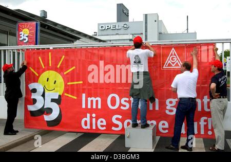 (Dpa) - sind Mitglieder der deutschen Metall Gewerkschaft IG Metall ein riesiges Banner an der Pforte des Opel-Werk in Eisenach, 12. Mai 2003 aufhängen. Das Banner sagt "die Sonne steigt im Osten" (im Osten Geht die Sonne Auf ") und zeigt das Logo einer Sonne lächelnd und über der Abbildung 35 scheint. Stockfoto