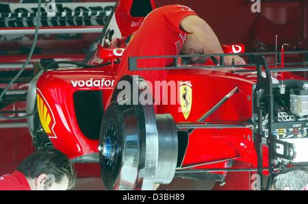 (Dpa) - Ferrari-Mechaniker arbeiten an der neuen Ferrari-Rennwagen F2003-GA von den deutschen Formel 1-Weltmeister Michael Schumacher auf der Rennstrecke Circuit de Catalunya in der Nähe von Barcelona, Spanien, 1. Mai 2003. Michael Schumacher fährt sein erste Rennen in der neuen Ferrari an diesem Wochenende beim großen Preis von S Stockfoto