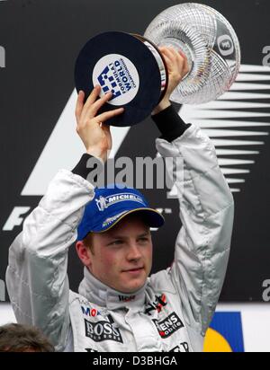 (Dpa) - der finnische Formel 1 Pilot Kimi Raeikkoenen (McLaren-Mercedes) hebt seine Trophäe hoch in die Luft nach dem nächsten Rang beim Grand Prix von San Marino auf der Rennstrecke in Imola, Italien, 20. April 2003. Raeikkoenen kommt mit 32 Punkten momentan erste in der Rangliste der Welt ch Stockfoto