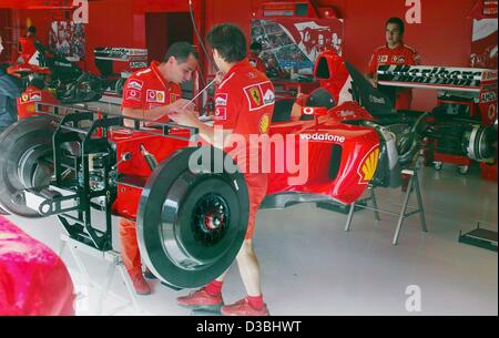 (Dpa) - Ferrari-Mechaniker arbeiten an der neuen Ferrari-Rennwagen F2003-GA von den deutschen Formel 1-Weltmeister Michael Schumacher auf der Rennstrecke Circuit de Catalunya in der Nähe von Barcelona, Spanien, 1. Mai 2003. Michael Schumacher fährt sein erste Rennen in der neuen Ferrari an diesem Wochenende beim großen Preis von S Stockfoto