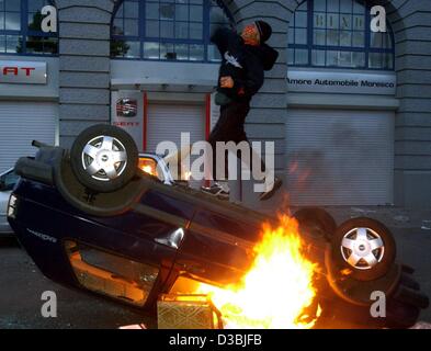 (Dpa) - einem wütenden Randalierer steht auf einem brennenden Auto und wirft einen Stein während der heute traditionellen Tag der Arbeit-Unruhen in Berlin, 1. Mai 2003. Nach Angaben der Polizei ihre wurden wieder neue Gewaltexzesse über die letzten zwei Nächte nach versuchen von der Polizei und Anwohner gescheitert t Stockfoto