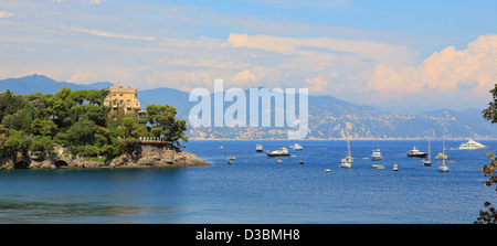 Ein Blick auf das alte Steinhaus unter den Bäumen auf einer Klippe ragt in die Bucht von Portofino am Mittelmeer in Italien. Stockfoto