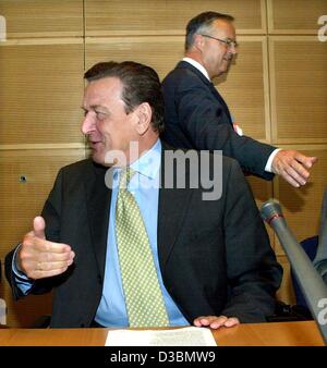 (Dpa) - geht der deutsche Finanzminister Hans Eichel im Hintergrund vorbei an Bundeskanzler Gerhard Schroeder, die während eines Gesprächs vor ein SPD-Partei-treffen in Berlin, 19. Mai 2003 zu lachen. Stockfoto