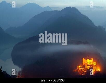 (Dpa) - steht Hohenschwangau Schloss hell Illimunated inmitten einer dunklen Nebel bedeckt Landschaft in der Abenddämmerung in der Nähe von Schwangau, Deutschland, 31. März 2003. Es wurde gebaut von 1832 bis 1836 von Kronprinz Maximilian im Neo-gotischen Stil auf den Ruinen der Schwanstein Schloss aus dem 12. Jahrhundert war b zerstört Stockfoto