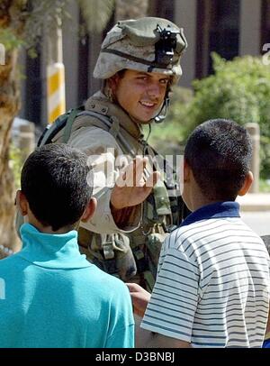 (Dpa) - eine US Soldat begrüßt zwei irakischen Jungen in Bagdad, 11. April 2003. Die gesamte medizinische Versorgung in Bagdad hat abgebaut, rotes Kreuz Beamten sagte. Krankenhäuser und Kliniken in der irakischen Hauptstadt sind geschlossen, die Patienten haben entweder geflohen oder sind links auf eigene Faust. Die steigende Temperatur erhöht das Risiko Stockfoto