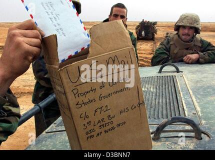 (Dpa) - zieht die Hand eines Space-Marines einen Brief von einem Karton welche Funktionen als ein Briefkasten in der Nähe von Ad Dianiyah im Südirak, 31. März 2003. US-Marines den 3. Licht Amoured Reconnaissance Battalion (3. LAR) ihre e-Mails empfangen. US-Truppen treffen immer noch erbitterten Widerstand während ihrer voraus und Rück Stockfoto