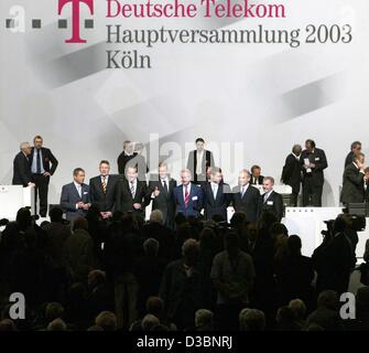 (Dpa) - Kai-Uwe Ricke (C), Vorstandsvorsitzender der Deutschen Telekom AG, gibt das Daumen-oben Zeichen steht er zwischen FCO Karl-Gerhard Eick und Klaus Zumwinkel (R), Vorsitzender des Aufsichtsrats, vor der Mitgliederversammlung (Hauptversammlung) in Köln (Köln), Deutschland, 20. Mai 2003. Im Jahr 2002 hatte das Unternehmen Stockfoto