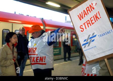 (Dpa) - weist ein markanten Eisenbahn-Mitarbeiter darauf hin, ein Passagier, die den Zugbegleiter auf eine Warnung Streik (Warnstreik) am regionalen Bahnhof in München, 6. März 2003. Die Deutsche Bahn Dirigent Gewerkschaft GDL hat für einen landesweiten Streik am 6. März aufgerufen fordern eine drei-Prozent Stockfoto