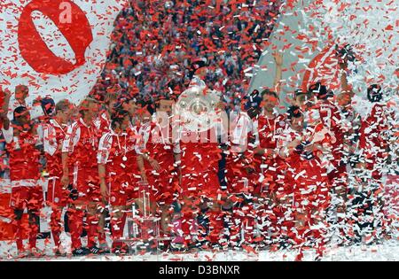 (Dpa) - feiern die Spieler der Fußball-Club Bayern München mit dem Bundesliga-Pokal (C) im Olympiastadion in München, 17. Mai 2003. FC Bayern München wurden deutsche Bundesliga Champions gekrönt, bereits nach ihrem Sieg am 26. April. Es ist ihre 18. Meistertitel. Stockfoto