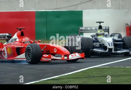 (Dpa) - deutscher Formel-1-Fahrer Michael Schumacher Ferrari (L) vermeidet nur knapp einen Zusammenstoß mit seinem Bruder Ralf Schumacher (R, BMW-Williams) in einer Kurve auf der Rennstrecke in Suzuka, Japan, 12. Oktober 2003. Schumacher platziert 8. im letzten Rennen der diesjährigen World Championship, gewann ein reco Stockfoto