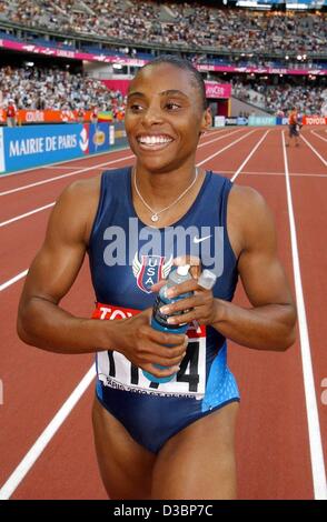 (Dpa) - US-Sprinter Kelli White eine Flasche Wasser in den Händen hält und ist alles Lächeln nach dem Gewinn der Frauen-100m-Finale bei der 9. athletische Weltmeisterschaften im Stade de France in Paris, 24. August 2003. Stockfoto