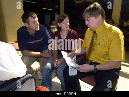 Johannes Domagala (R), Mitarbeiter der deutschen Botschaft in Colombo, informiert über Möglichkeiten der Rückkehr nach Deutschland auf dem Flughafen in Colombo, Sri Lanka, Donnerstag, 30. Dezember 2004 Juliane Hoyer aus Leipzig, Deutschland, und ihr Freund Roberto Stoll. Das Paar überstanden die Bohrung in Hikkaduwa unverletzt Stockfoto