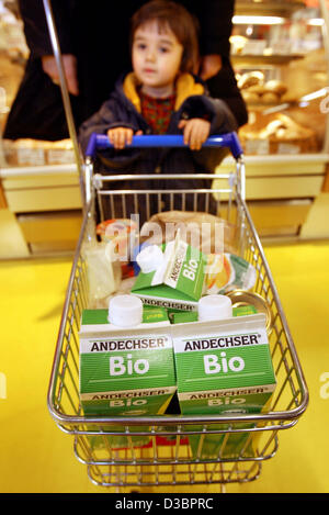 (Dpa-Dateien) - hilft ein kleines Kind seine Mutter Push der Einkaufswagen auf dem Bio-Supermarkt "Basic" in Frankfurt am Main, 4. März 2004. Der Supermarkt, das gehört zu einer kleinen Kette von Bioläden, verkauft nur organische hergestellte waren. Stockfoto