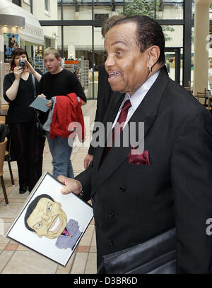 (Dpa) - Joseph Jackson, Vater von Popstar Michael Jackson hält eine Zeichnung von sich selbst in der Hand als er steht im Foyer des Estrel Hotel in Berlin, 22. Juli 2005. Ein Fan präsentierte die Zeichnung Jackson als Geschenk anlässlich seinem 76. Geburtstag, die er heute gefeiert. Die Jackson Stockfoto