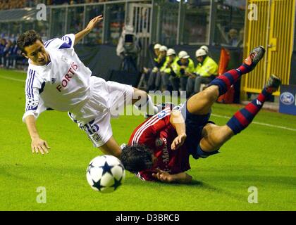 (Dpa) - Münchens Mittelfeldspieler Michael Ballack (R) auf den Boden fällt, als er mit Anderlecht des albanischen Mittelfeldspieler Besnik Hasi für den Ball in der Champions League-Fußball-Spiel RSC Anderlecht gegen Bayern München in Brüssel, 30. September 2003 kämpft. Das Spiel endete mit einem 1: 1-Unentschieden. Stockfoto