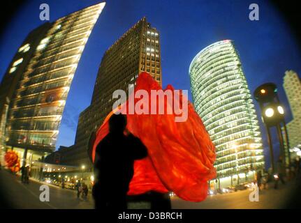 (Dpa) - ein Passant bewundert einen beleuchteten riesigen Plastik stieg am Potsdamer Platz in Berlin, Deutschland, 30. September 2003. 80 der bunten Blüten sind am Potsdamer Platz (Potsdamer Platz) vor den DaimlerChrysler-Büros anlässlich des Daimler fünf-Jahr-Jubiläum in festgelegt werden Stockfoto