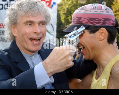 (Dpa) - britischer Chefdirigent der Berliner Philharmoniker, Sir Simon Rattle (L) hält ein Starter Pistole an den Kopf von Christian Hartmann, ein Marathon-Läufer aus Berlin und beide Männer Lächeln kurz vor dem Start der 30. Berlin-Marathon in Berlin, 28. September 2003. Rund 35.000 Läufer aus 91 c Stockfoto