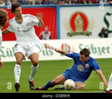 (Dpa) - Rostocker Verteidiger Jochen Kientz (R) Folien auf dem Spielfeld während er in das Trikot der Bayern Mittelfeldspieler Michael Ballack (L) im Kampf um den Ball während der Fußball-Bundesliga zieht-Spiel FC Bayern München gegen FC Hansa Rostock in Rostock, Deutschland, 27. September 2003. Bayern-Muni Stockfoto