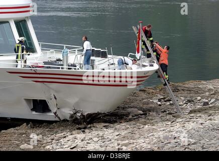 (Dpa) - liegt das beschädigte touristischen Motorboot "Loreley" gestrandet auf einer Sandbank während Mitglieder der Feuerwehr auf das Boot am Rhein in der Nähe von St. Goar, Deutschland, 28. September 2003 zu steigen. Der Unfall ereignete sich, als das Touristenboot hatte einen großen Stein auf das Flussbett aufgrund der niedrigen Wasserständen getroffen Stockfoto