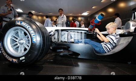 (Dpa) - sitzt ein kleiner Junge in einen Formel 1 Rennwagen, der entlang der Rollachse des Autos am Stand für sportliche Autos von Daimler-Chrysler auf der internationalen Auto Show IAA in Frankfurt am Main, 12. September 2003 aufgeschnitten ist. Von 12 September bis 21 September die Messe mit rund 1.000 Exhibitione Stockfoto