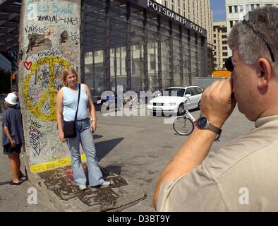 (Dpa) - ein Tourist nimmt ein Foto seiner Tochter posiert vor einem Rest der Berliner Mauer am Potsdamer Platz (Potsdamer Platz) im Zentrum von Berlin, 13. August 2003. In den frühen Morgenstunden des 13. August 1961 Stacheldraht und Draht Verstrickungen über Access Points zu West-Berlin platziert waren und die er Stockfoto