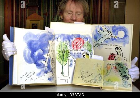 (Dpa) - Mitarbeiter Joachim Pruesse drei kostbare Buch zeigt mit Originalgemälden des russischen Künstlers Marc Chagall (1887-1985) an der Kirche St. Martin in Brunswick (Braunschweig), Deutschland, 5. September 2003. Chagall hatte die Bilder zwischen 1968 und 1973 für einen Sammler in London gemacht. Das bo Stockfoto