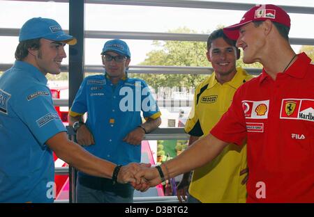 (Dpa) - deutscher Formel-1-Weltmeister Michael Schumacher (R) von Ferrari und Spaniens Fernando Alonso (L) von Renault Hände schütteln während italienische Formel 1 Piloten Jarno Trulli von Renault (2. v. L) und Giancarlo Fisichella der Jordanfurt schauen Sie auf, an der Rennstrecke in Monza, Italien, 11. September 2003. Th Stockfoto